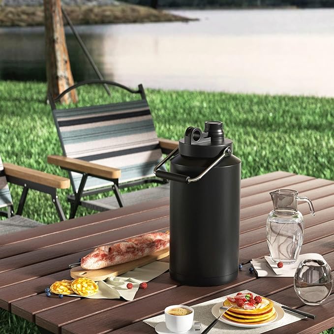 The Kerilyn insulated jug on a table next to food and chairs in the outdoors.