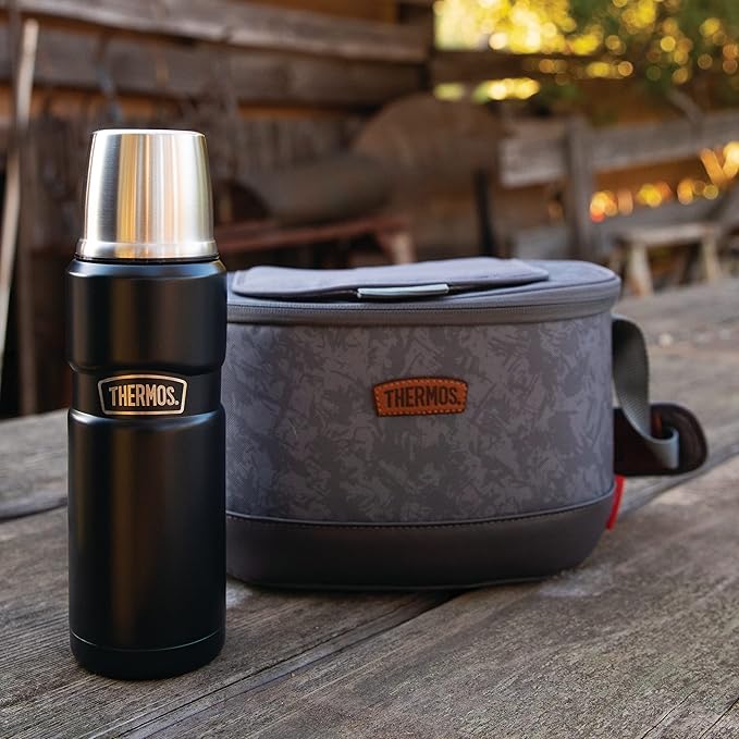 The Thermos King 16 ounce insulated thermos new to a Thermos branded lunchbox on a table.