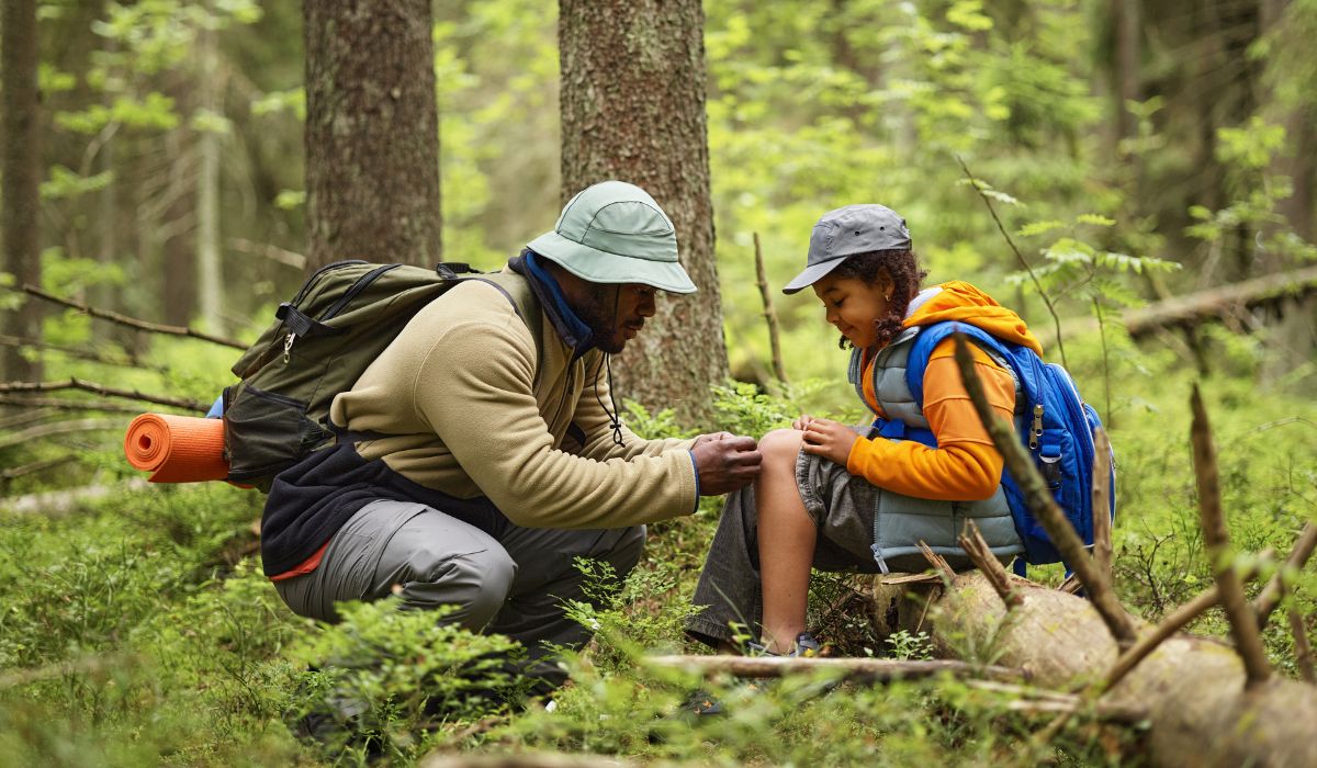 A person treating another person on a camping trip with an injury